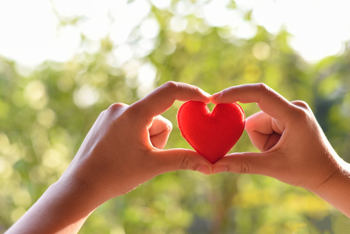 Heart in hand for philanthropy concept - woman holding red h